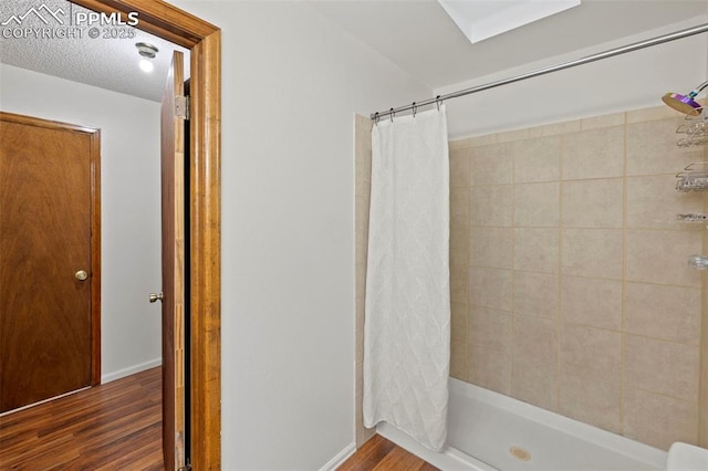 6947 Gayle Lyn Ln, Colorado Springs, CO 80919 - full bath with wood finished floors, tiled shower, and baseboards
