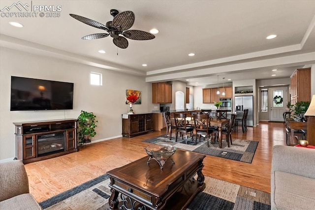 7890 Treehouse Ter, Fountain, CO 80817 - living area featuring a tray ceiling, a ceiling fan, recessed lighting, and light wood finished floors