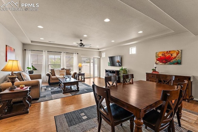7890 Treehouse Ter, Fountain, CO 80817 - dining space with wood finished floors, ceiling fan, a tray ceiling, a textured ceiling, and recessed lighting