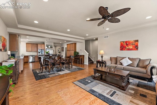 7890 Treehouse Ter, Fountain, CO 80817 - living room featuring stairs, ceiling fan, wood finished floors, a raised ceiling, and recessed lighting