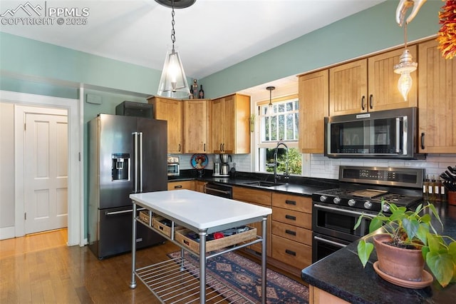 20 W Caramillo St, Colorado Springs, CO 80907 - kitchen featuring stainless steel appliances, a sink, tasteful backsplash, wood finished floors, and decorative light fixtures