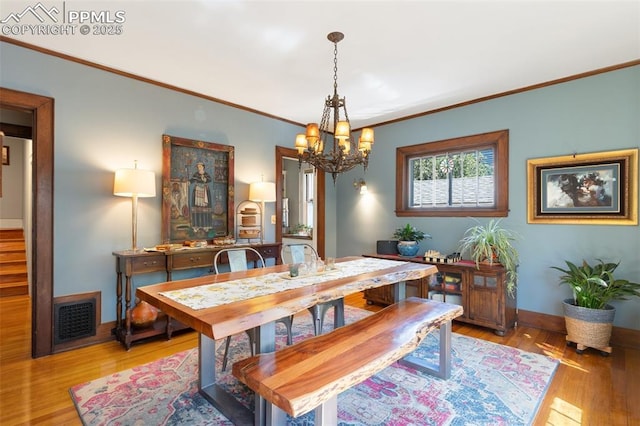 20 W Caramillo St, Colorado Springs, CO 80907 - dining room featuring a chandelier, light wood-style flooring, ornamental molding, baseboards, and stairway