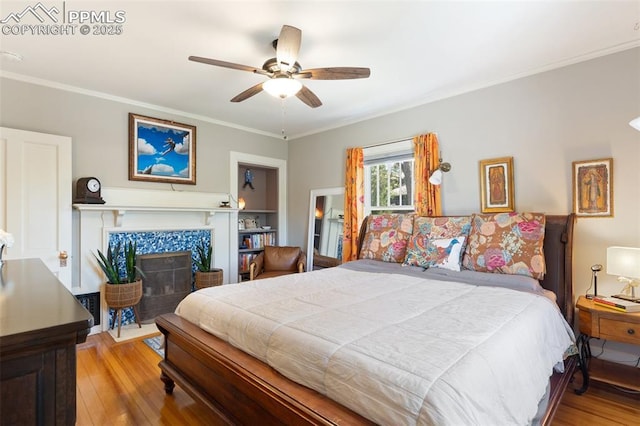 20 W Caramillo St, Colorado Springs, CO 80907 - bedroom with wood finished floors, crown molding, a tiled fireplace, and ceiling fan