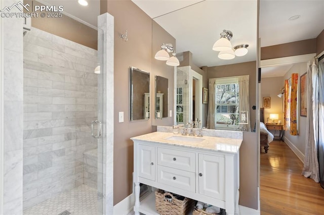 20 W Caramillo St, Colorado Springs, CO 80907 - ensuite bathroom with a shower stall, vanity, wood finished floors, and baseboards