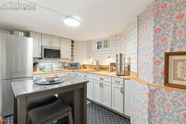 20 W Caramillo St, Colorado Springs, CO 80907 - kitchen featuring stainless steel appliances, a sink, open shelves, light countertops, and wallpapered walls