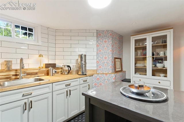 20 W Caramillo St, Colorado Springs, CO 80907 - kitchen featuring a sink, glass insert cabinets, light countertops, and backsplash