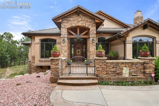 1624 Oakmoor Hts, Colorado Springs, CO 80906 - view of front of property with stone siding, a chimney, stucco siding, a tiled roof, and a gate