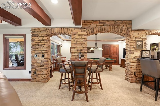 1624 Oakmoor Hts, Colorado Springs, CO 80906 - dining area featuring arched walkways, decorative columns, light colored carpet, beamed ceiling, and plenty of natural light