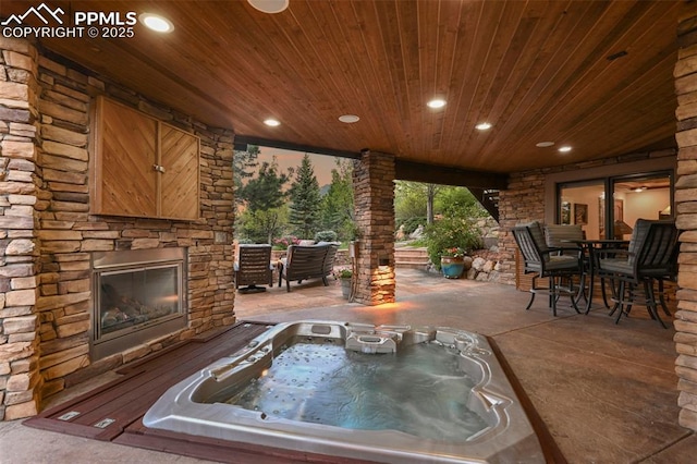 1624 Oakmoor Hts, Colorado Springs, CO 80906 - view of patio / terrace with an outdoor stone fireplace, an outdoor hot tub, and outdoor dining area