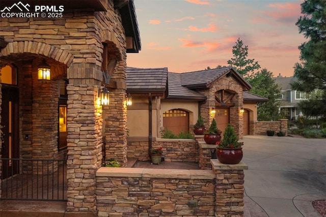 1624 Oakmoor Hts, Colorado Springs, CO 80906 - view of front facade featuring concrete driveway, stone siding, and stucco siding