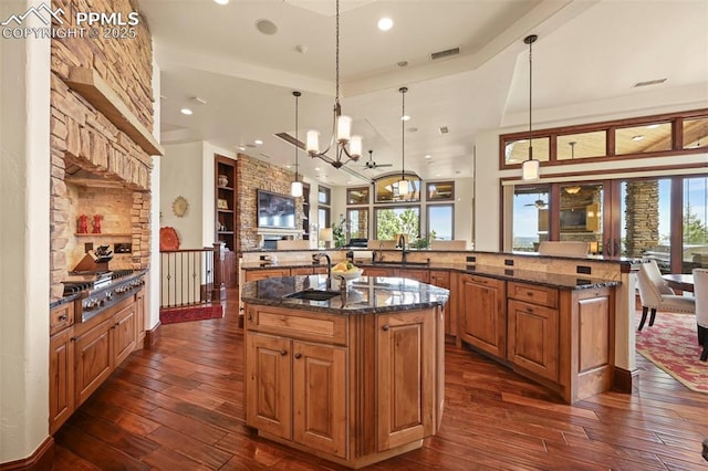 1624 Oakmoor Hts, Colorado Springs, CO 80906 - kitchen featuring a large island with sink, a sink, dark wood-style flooring, brown cabinetry, and stainless steel gas cooktop