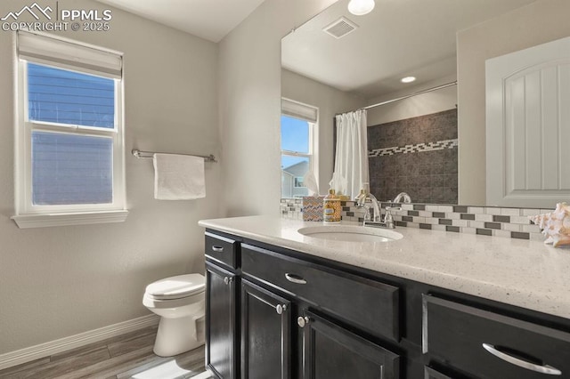 13124 Park Meadows Dr, Peyton, CO 80831 - bathroom featuring baseboards, toilet, a tile shower, wood finished floors, and vanity