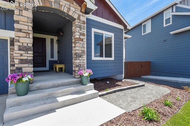 13124 Park Meadows Dr, Peyton, CO 80831 - doorway to property with board and batten siding and stone siding