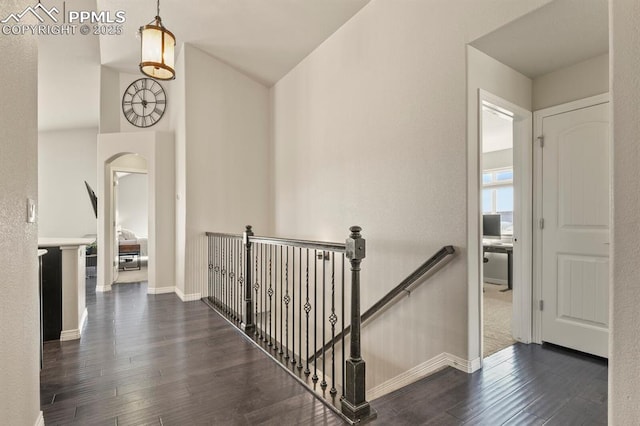 13124 Park Meadows Dr, Peyton, CO 80831 - corridor with an upstairs landing, arched walkways, dark wood finished floors, baseboards, and lofted ceiling