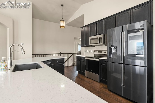 13124 Park Meadows Dr, Peyton, CO 80831 - kitchen featuring stainless steel appliances, a sink, dark cabinets, light stone counters, and vaulted ceiling