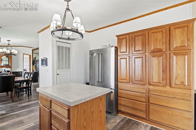 10635 Via Vaquaro Pt, Fountain, CO 80817 - kitchen with high quality fridge, a chandelier, a kitchen island, crown molding, and dark wood-style floors