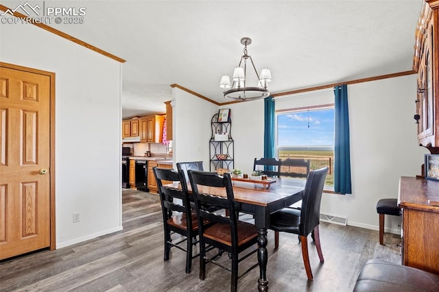 10635 Via Vaquaro Pt, Fountain, CO 80817 - dining room with a chandelier, baseboards, wood finished floors, and ornamental molding
