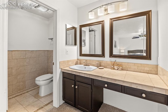 6424 Rifle Cir, Colorado Springs, CO 80919 - bathroom featuring vanity, tile walls, a wainscoted wall, and tile patterned floors