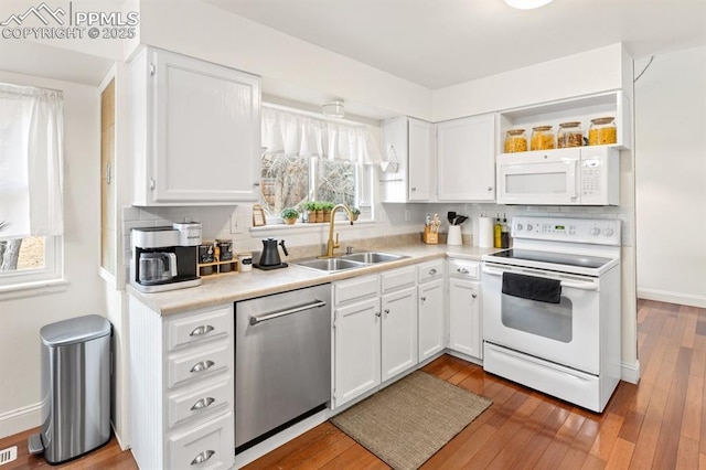 6424 Rifle Cir, Colorado Springs, CO 80919 - kitchen with white appliances, white cabinetry, light countertops, and backsplash