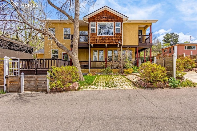321 Graceland Grv, Colorado Springs, CO 80904 - view of front facade featuring a balcony, stucco siding, and fence