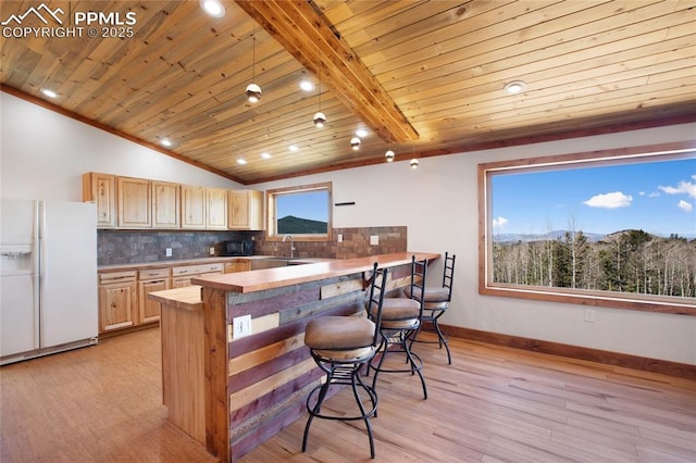 2747 County Road 61, Cripple Creek, CO 80813 - kitchen with white refrigerator with ice dispenser, lofted ceiling, tasteful backsplash, a sink, and a breakfast bar area