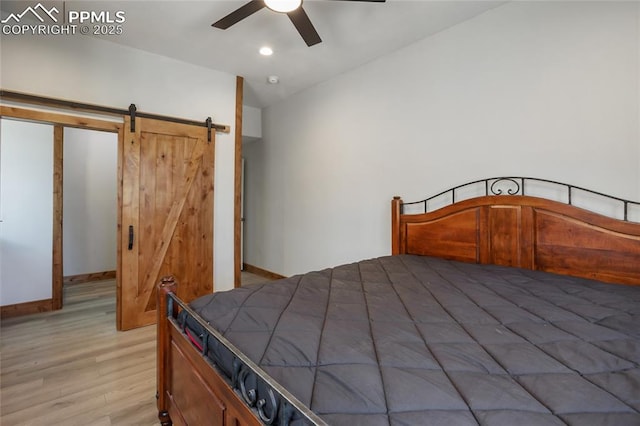 2747 County Road 61, Cripple Creek, CO 80813 - bedroom featuring light wood-style floors, a barn door, baseboards, and a ceiling fan