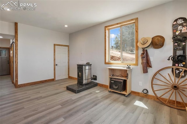 2747 County Road 61, Cripple Creek, CO 80813 - living room featuring light wood-type flooring, a wood stove, baseboards, and recessed lighting