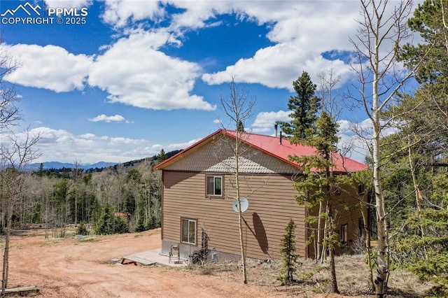2747 County Road 61, Cripple Creek, CO 80813 - view of side of home featuring a mountain view, a patio, and a wooded view