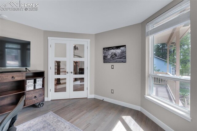 unfurnished living room with french doors, wood finished floors, and baseboards