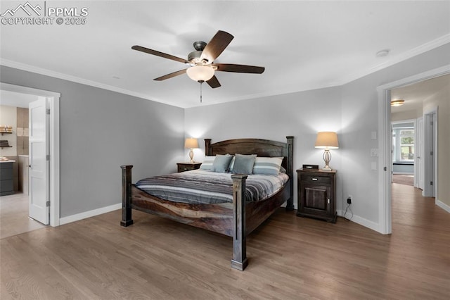 bedroom with light wood-type flooring, ornamental molding, baseboards, a ceiling fan, and ensuite bathroom