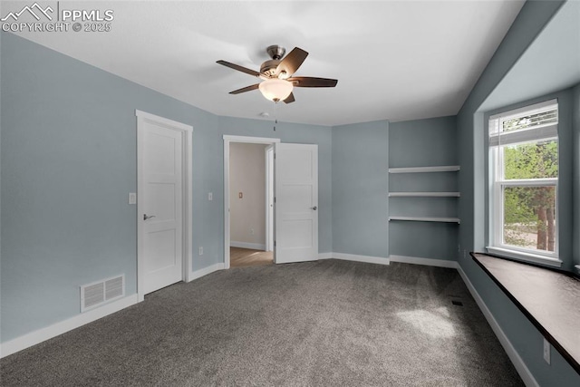 carpeted spare room featuring a ceiling fan and baseboards