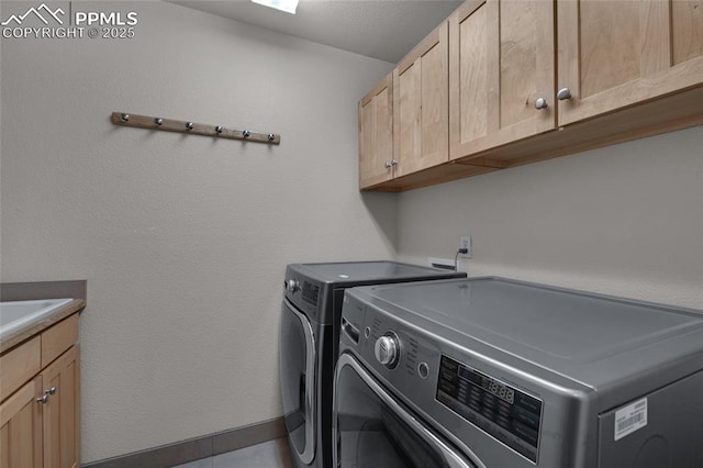 clothes washing area featuring cabinet space and washing machine and dryer
