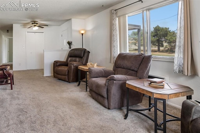 living area featuring ceiling fan and carpet