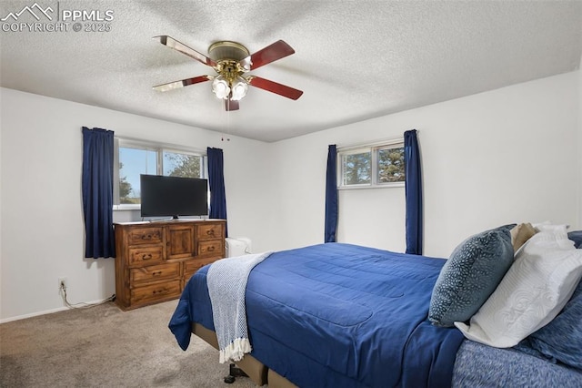 carpeted bedroom featuring ceiling fan and a textured ceiling