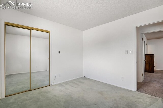 unfurnished bedroom with carpet floors, a closet, and baseboards