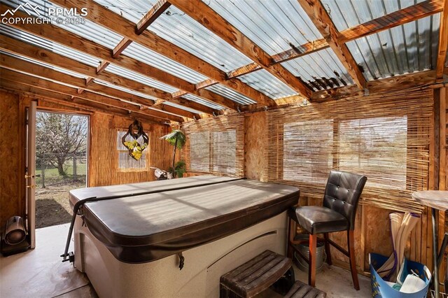misc room with unfinished concrete flooring and wood walls