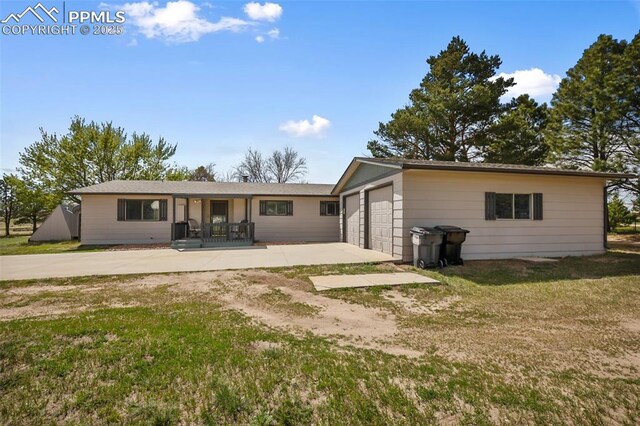 back of property with a yard and covered porch