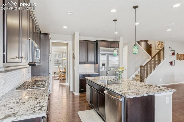 3197 Cool Meadow Pl, Castle Rock, CO 80104 - kitchen featuring stainless steel appliances, a sink, dark brown cabinetry, decorative backsplash, and recessed lighting