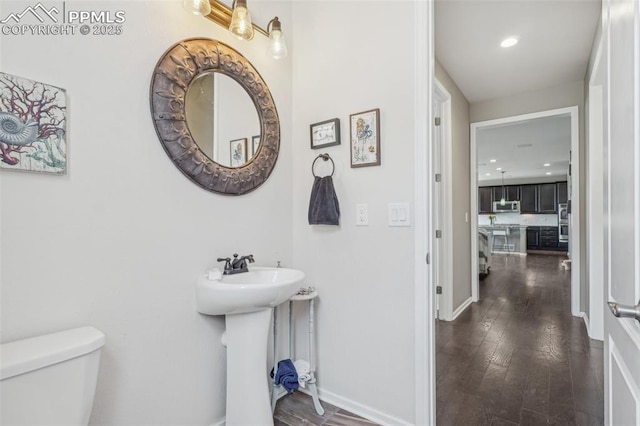 3197 Cool Meadow Pl, Castle Rock, CO 80104 - half bath featuring toilet, baseboards, recessed lighting, wood finished floors, and a sink