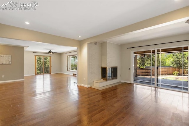 1303 Hermosa Way, Colorado Springs, CO 80906 - unfurnished living room with wood finished floors, ceiling fan, baseboards, recessed lighting, and a multi sided fireplace