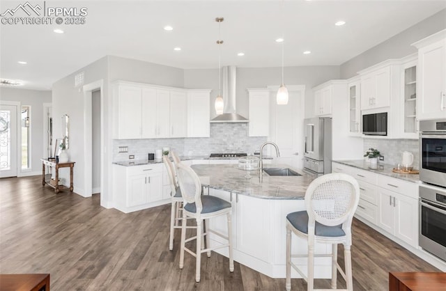 19887 Kershaw Ct, Monument, CO 80132 - kitchen featuring wall chimney exhaust hood, a sink, high end fridge, tasteful backsplash, and recessed lighting