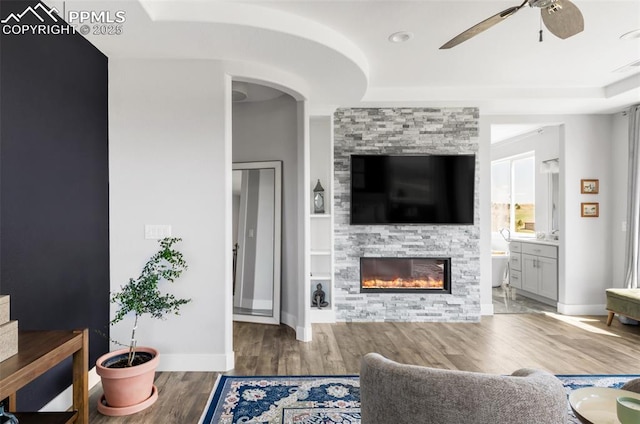 19887 Kershaw Ct, Monument, CO 80132 - living room featuring a ceiling fan, wood finished floors, a fireplace, and baseboards