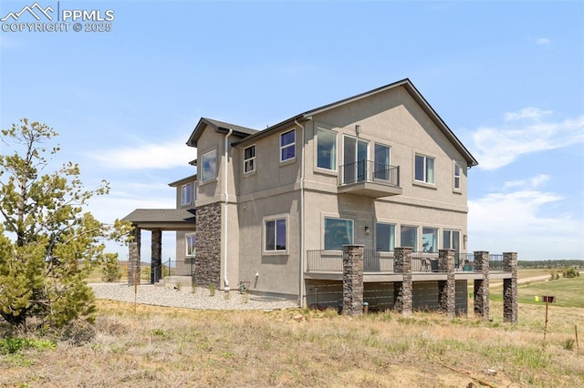 19887 Kershaw Ct, Monument, CO 80132 - view of home's exterior with stucco siding, a balcony, and stone siding