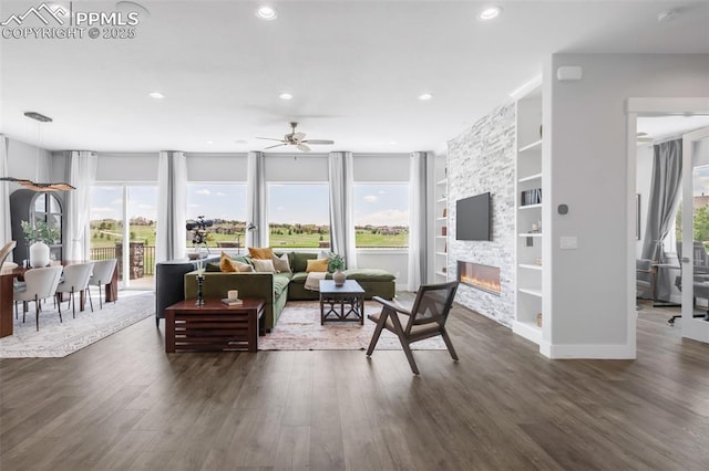 19887 Kershaw Ct, Monument, CO 80132 - living room featuring built in features, dark wood-style floors, a ceiling fan, a fireplace, and recessed lighting