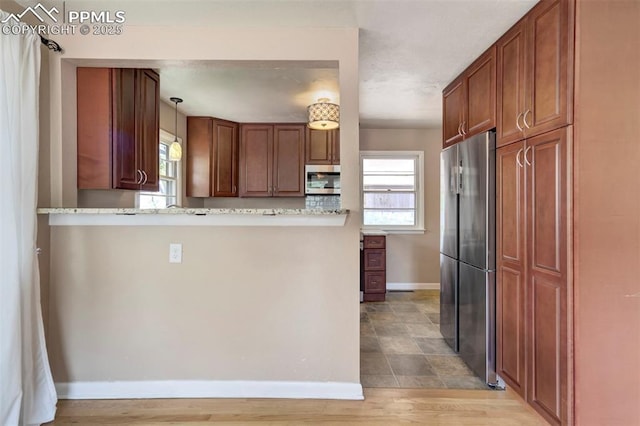 717 W Monroe St, Colorado Springs, CO 80907 - kitchen featuring stainless steel appliances, baseboards, pendant lighting, light countertops, and brown cabinetry