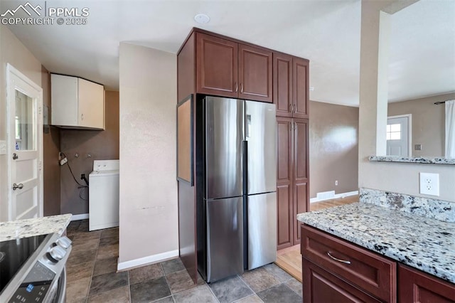717 W Monroe St, Colorado Springs, CO 80907 - kitchen featuring appliances with stainless steel finishes, washer / dryer, baseboards, light stone counters, and dark stone finish floors