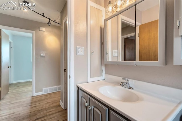 717 W Monroe St, Colorado Springs, CO 80907 - bathroom featuring wood finished floors, vanity, track lighting, and baseboards