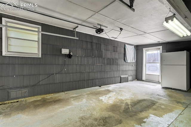 717 W Monroe St, Colorado Springs, CO 80907 - garage featuring freestanding refrigerator and a garage door opener