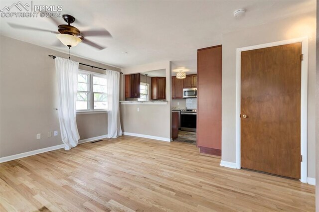 717 W Monroe St, Colorado Springs, CO 80907 - unfurnished living room featuring a ceiling fan, light wood-style flooring, and baseboards
