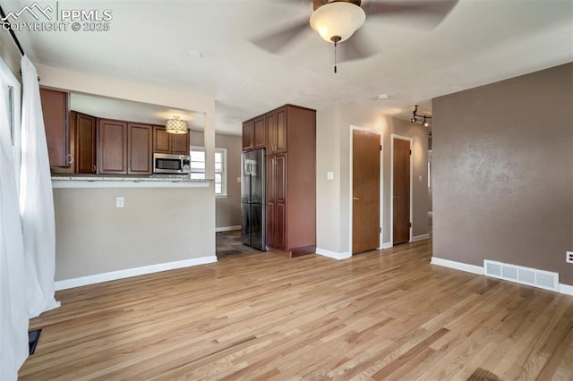 717 W Monroe St, Colorado Springs, CO 80907 - kitchen featuring stainless steel appliances, ceiling fan, light wood-style flooring, baseboards, and open floor plan